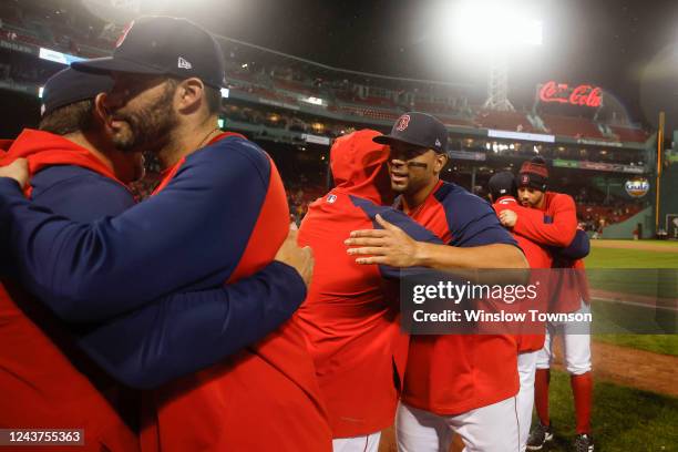 Xander Bogaerts of the Boston Red Sox, center, and J.D. Martinez, left, hug teammates following the final game of their season, a 6-3 win over the...