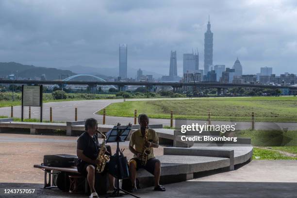 People play the saxophones in front of the Taipei skyline in Taoyuan, Taiwan, on Wednesday, Oct. 5, 2022. Taiwan warned it would treat any Chinese...