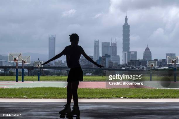 Woman roller skates in front of the Taipei skyline in Taoyuan, Taiwan, on Wednesday, Oct. 5, 2022. Taiwan warned it would treat any Chinese incursion...