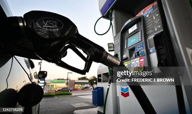 Nozzle pumps gasoline into a vehicle at a gas station in Los Angeles, California on October 5, 2022. - Saudi Arabia, Russia and other top oil...
