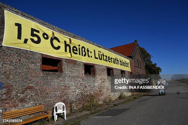 This picture taken on October 5, 2022 shows a banner of climate activists on the wall of a house reading: "1,5 degrees celsius means: Luetzerath...