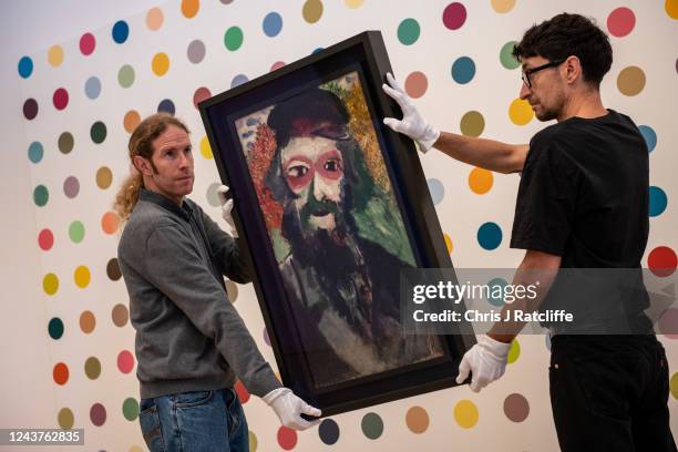 Art handlers hold Le Pere, a portrait by artist Marc Chagall of his father, during a press preview at Phillips gallery on October 6, 2022 in London,...