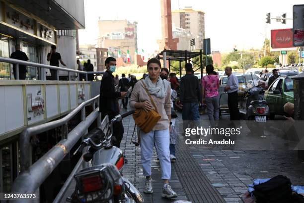 People walk on a sidewalk as anti-government protests following death of Mahsa Amini, a 22-year-old Iranian woman, who was arrested in Tehran on 13...