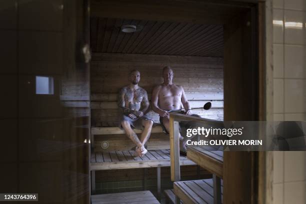 Jukka Maekinen, a 39-year-old Finnish fireman, and Dan Jaervinen, a 55-year-old Finnish fireman, pose in the firestation sauna in Vaasa on September...