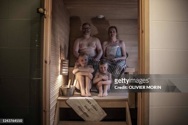 Tomas Stahl, a 43-year-old Finn , his wife Jaana Stahl and their sons Noa and Urho Bottom R pose in their home Sauna in Vaasa on September 10, 2022....