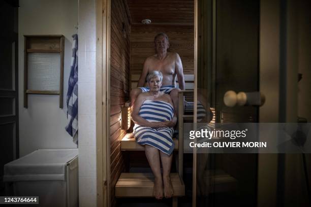 Bo Stahl, a 76-year-old Finn, and his wife Leena Stahl pose in their home Sauna in Vaasa on September 10, 2022. - Finns are being urged to turn down...