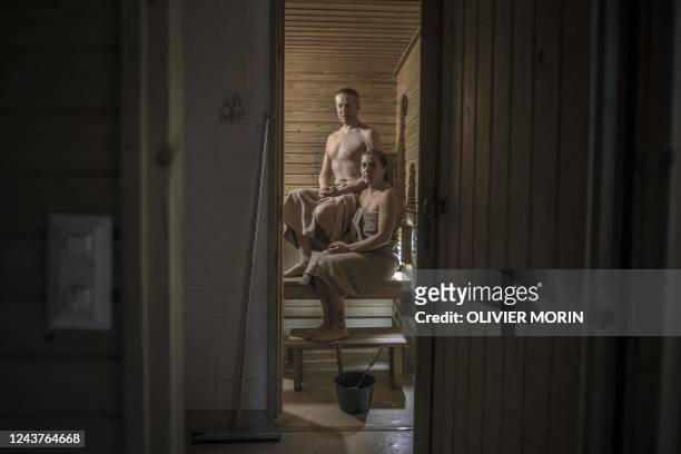 Kristian Maki-Jussila, a 39-year-old Finn , and his partner, Henrietta Kivijaervi pose in a sauna in Vaasa on September 11, 2022. - Finns are being...