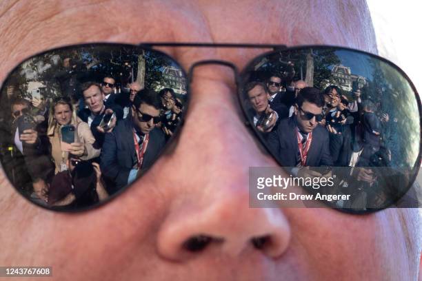 Reporters are reflected in the sunglasses of U.S. President Joe Biden as he speaks to the press before boarding Marine One on the South Lawn of the...