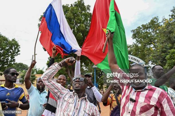 Supporters of Burkina Faso's new junta leader Ibrahim Traore hold national flags of Burkina Faso and Russia during a demonstration near the national...