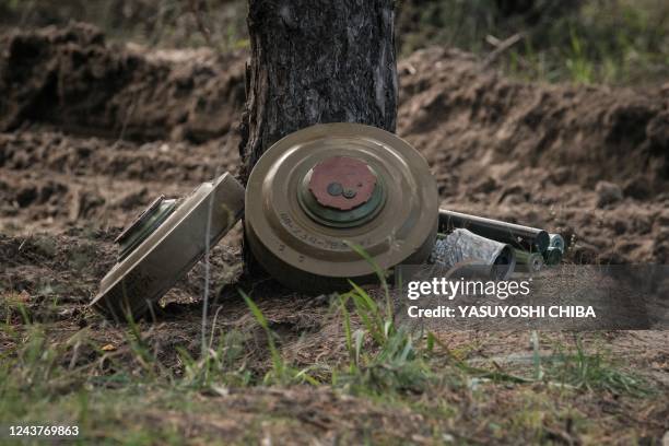 Collected anti-tank mines and explosives are set to detonate by the Ukrainian national police emergency demining team near the recently retaken town...