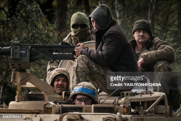 Ukrainian soldiers ride on an armoured vehicle near the recently retaken town of Lyman in Donetsk region on October 6 amid the Russian invasion of...