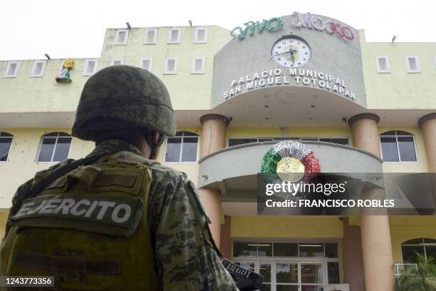 Member of the Mexican Army stands guard in front of the bullet-ridden facade of the Municipality of San Miguel Totolapan building, state of Guerrero,...