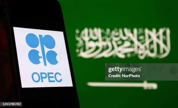 Logo displayed on a phone screen and Saudi Arabian flag displayed on a screen in the background are seen in this illustration photo taken in Poland...