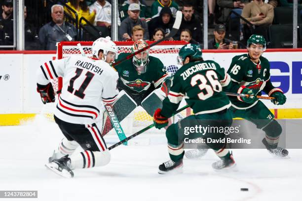 Filip Gustavsson of the Minnesota Wild defends his net against Taylor Raddysh of the Chicago Blackhawks as Mats Zuccarello and Jared Spurgeon of the...