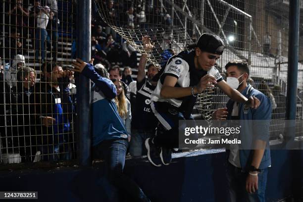 Fans of Gimnasia y Esgrima La Plata affected by tear gas jump the fence into the field of play after a match between Gimnasia y Esgrima La Plata and...