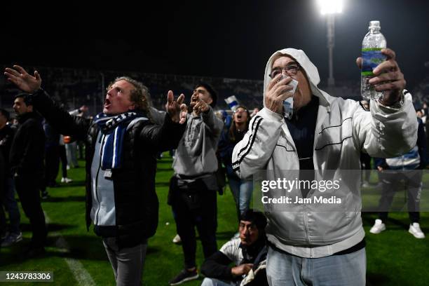 Fans of Gimnasia y Esgrima La Plata affected by tear gas cover their faces and chant covers her face after a match between Gimnasia y Esgrima La...