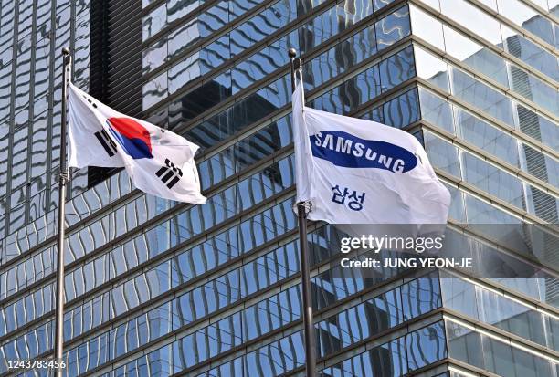 South Korean naitonal flag and a Samsung flag flutter outside the company's Seocho building in Seoul on October 7 after Samsung Electronics expected...