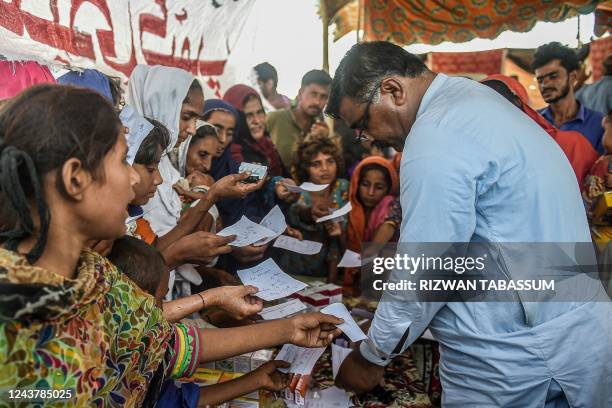 In this picture taken on September 27 internally displaced flood-affected people hold out their doctors prescriptions to get medicine at a medical...