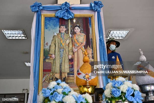 Worker sets up a portrait of Thailand's King Maha Vajiralongkorn and Queen Suthida ahead of their visit to the hospital in Thailand's Nong Bua Lam...