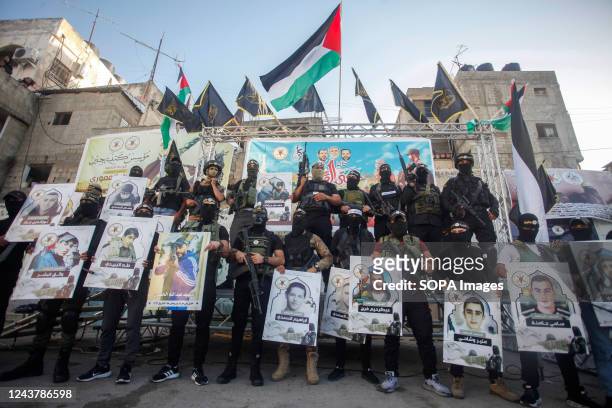 Palestinian gunmen from the Jenin battalion and the Islamic Jihad movement carry pictures of Palestinian martyrs, who were killed during the clashes...