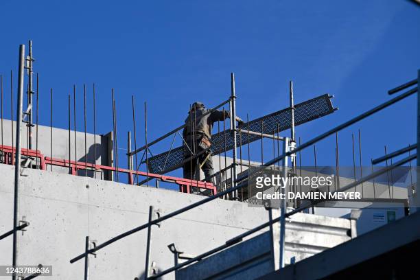 This picture taken on October 7, 2022 shows a construction worker on an apartment building site in Tinteniac, western France.