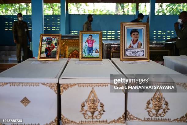 Portraits of young victims, including Nannaphat "Stamp" Songserm , of a mass shooting in a nursery are displayed atop their coffins as funeral...