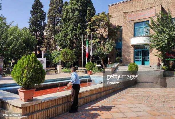 Picture obtained by AFP outside Iran on October 7, 2022 shows a man looking at the water, reportedly coloured red in protest against a deadly...