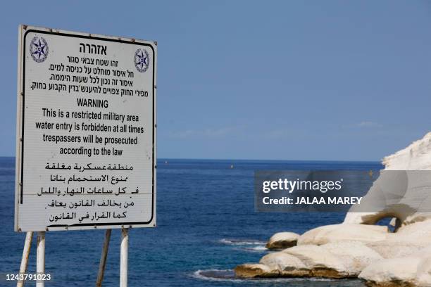 Sign written in Hebrew, English and Arabic designating a military area, stands overlooking the Mediterranean Sea in Israel's Rosh Hanikra, at the...