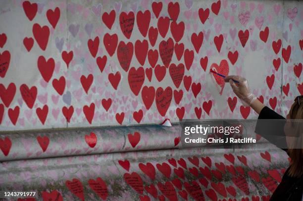 Volunteers re-paint hearts that have faded at the National Covid Memorial Wall on October 7, 2022 in London, England. The UK Office of National...
