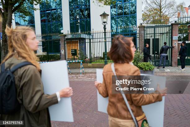 Men enter the embassy of Iran as human rights activists of Amnesty International stage a protest outside the embassy of Iran on October 7, 2022 in...