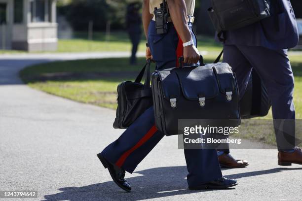 Military aide carries the "nuclear football," which contains launch codes for nuclear weapons, as he follows US President Joe Biden, not pictured,...