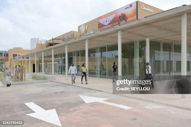 People walk near newly opened Pathe cinema in Dakar on October 7, 2022. - The French cinema giant, Pathe, opened on October 6 in Dakar a movie...