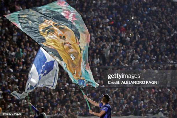 Fan of Gimnasia y Esgrima waves a flag with the image of former Argentinian football star Diego Maradona before the Argentine Professional Football...