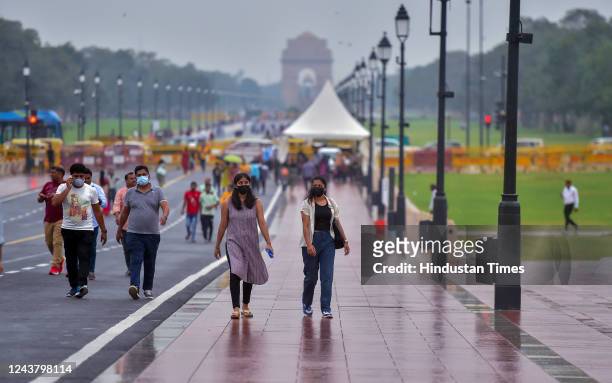 Commuters out in the rain on Kartavya Path near India Gate, on October 7, 2022 in New Delhi, India.