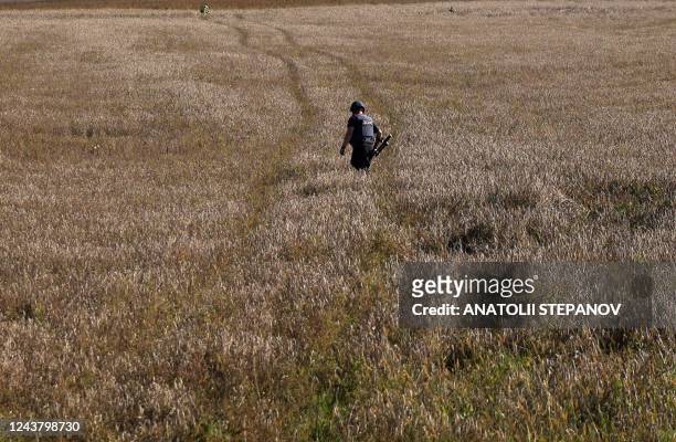 Ukrainian serviceman searches for land mines in a wheat field in Donetsk region on October 7, 2022.