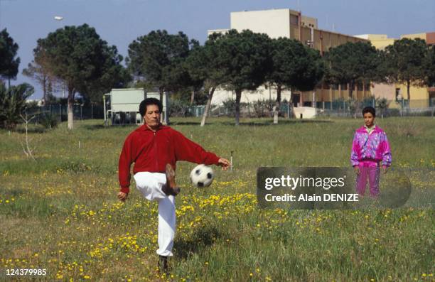 Libyan leader Muammar Gaddafi kicks a football as one his sons looks on in the military barracks of Bab al-Azizia on March 18, 1992 in Tripoli. Libya.