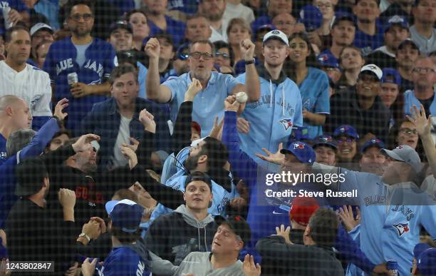 Fans try to catch a foul ball as the Toronto Blue Jays fall to the Seattle Mariners 4-0 in game one of their American League Wild Card series at...