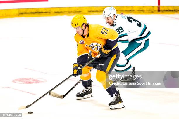 Dante Fabbro of the Nashville Predators plays the puck as Logan Couture of the San Jose Sharks pursues the play during the 2022 NHL Global Series...