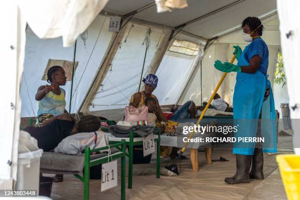 Worker speaks with a woman as people showing symptoms of cholera receive treatment at a clinic run by Doctors Without Borders in Cité Soleil a...