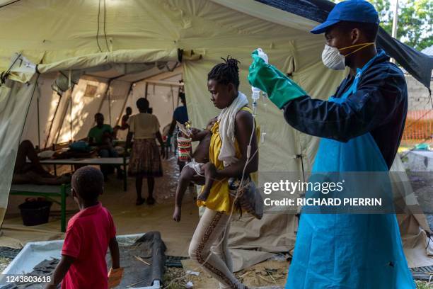 Woman brings her child showing symptoms of cholera to receive treatment at a clinic run by Doctors Without Borders in Cité Soleil a densely populated...