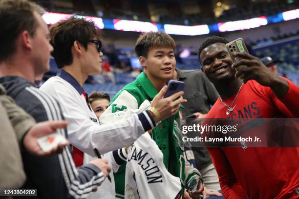 Zion Williamson of the New Orleans Pelicans takes a selfie with a fan before the game against the Detroit Pistons on October 7, 2022 at the Smoothie...