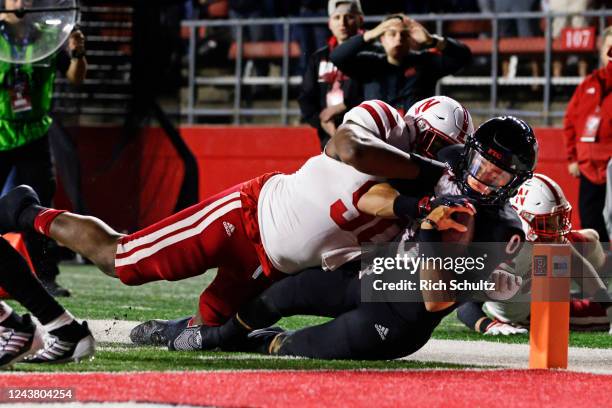 Quarterback Noah Vedral of the Rutgers Scarlet Knights is tackled in the end zone by Stephon Wynn Jr. #90 of the Nebraska Cornhuskers for a touchdown...