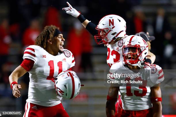 Malcolm Hartzog of the Nebraska Cornhuskers celebrates his interception with teammates Braxton Clark Isaac Gifford during the fourth quarter against...