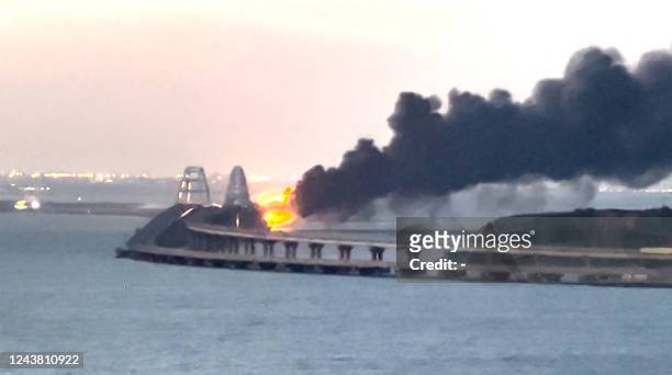 This video grab taken and released on October 8, 2022 shows thick black smoke rising from a fire on the Kerch bridge that links Crimea to Russia. -...