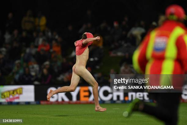 Graphic content / A ground security personnel runs after a streaker during the second cricket match between New Zealand and Pakistan in the Twenty20...