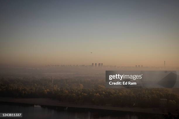 Helicopter flies at dawn as the sun rises over the Dnipro River on October 8, 2022 in central Kyiv, Ukraine. In recent weeks, Ukraine has made...