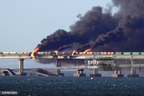 Black smoke billows from a fire on the Kerch bridge that links Crimea to Russia, after a truck exploded, near Kerch, on October 8, 2022. Moscow...