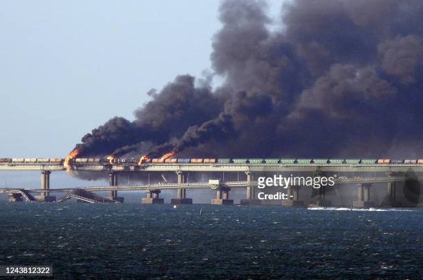 Black smoke billows from a fire on the Kerch bridge that links Crimea to Russia, after a truck exploded, near Kerch, on October 8, 2022. - Moscow...
