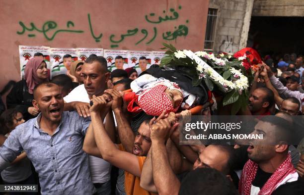 Graphic content / Mourners carry the flag-draped body of Palestinian Mahdi Mohammed Ladado, killed a day earlier in the occupied West Bank village of...