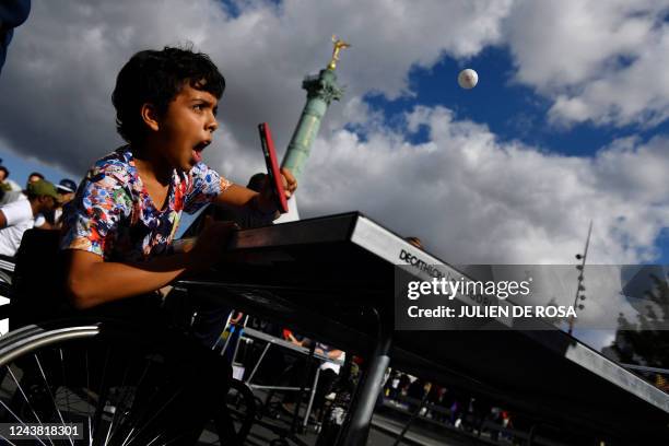 Child tries table tennis in a wheelchair during the first edition of the Paralympic Day on the Place de la Bastille in Paris on October 8 before the...